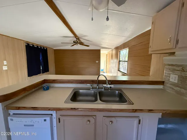 a kitchen with a sink a counter space and cabinets
