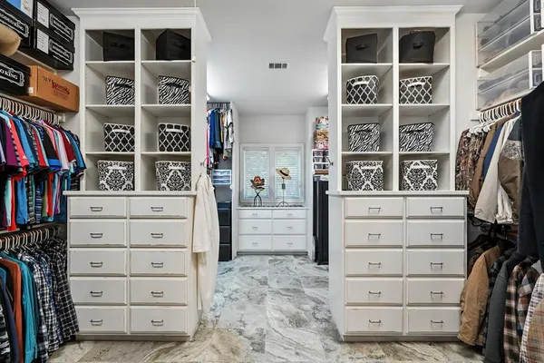 a view of walk in closet with clothes