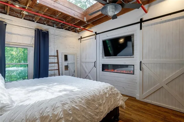 a spacious bedroom with a bed and a flat screen tv