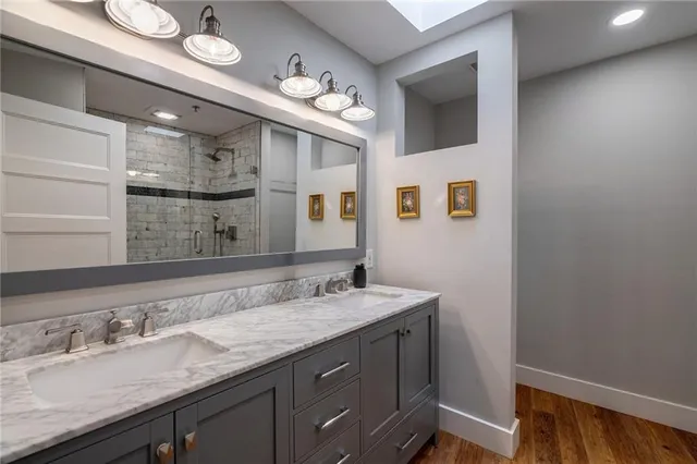 a bathroom with a granite countertop sink a large mirror and vanity