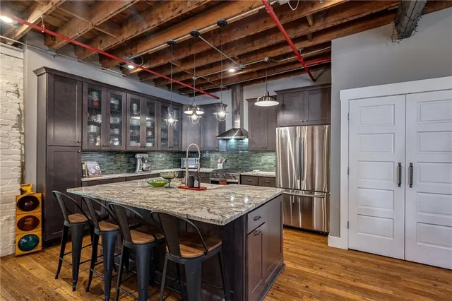 a kitchen with stainless steel appliances granite countertop a table chairs and wooden floor