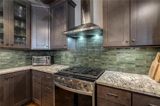 a kitchen with granite countertop cabinets and stove top oven