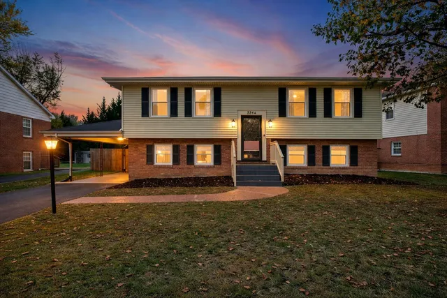 a view of a house with a big yard and large tree