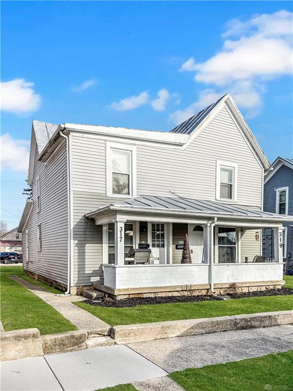 This charming residence features a welcoming front porch, perfect for enjoying sunny afternoons.