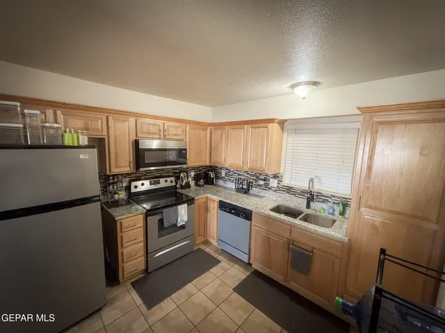 a kitchen with a stove a refrigerator and a counter top space