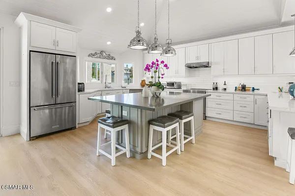 a kitchen with white cabinets and sink