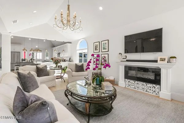 a living room with furniture a fireplace and a chandelier