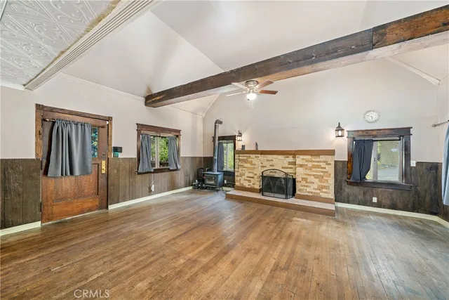 wooden floor fireplace and windows in an empty room