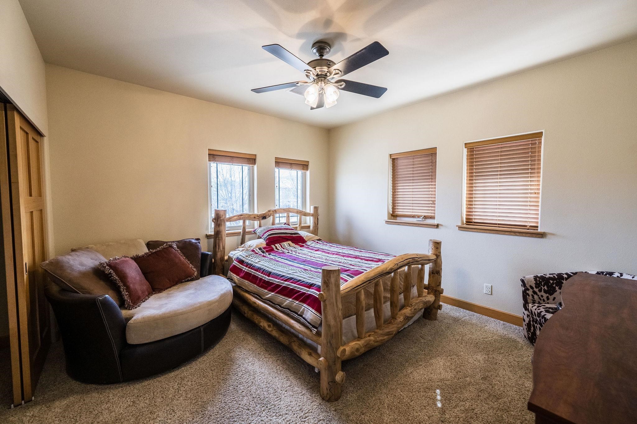 2069 Spur Cross Road Grand Junction, CO 81507 - Photo 26 of 40 a bedroom with a bed couch and window