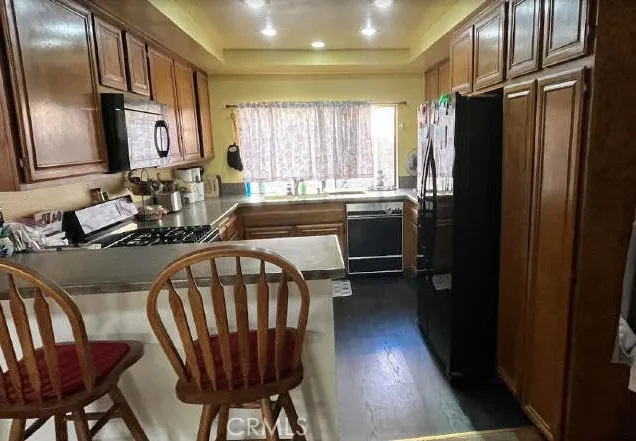 a kitchen with stainless steel appliances granite countertop a refrigerator a sink a stove and island