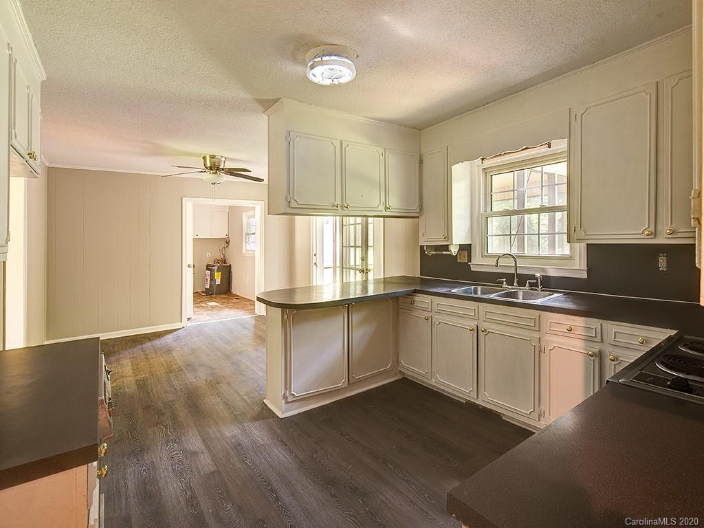 858 State Rd S-29-376 Lancaster, SC 29720 - Photo 6 of 28 a large white kitchen with wooden floor and a sink