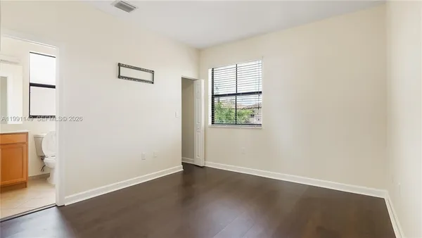 an empty room with wooden floor and closet