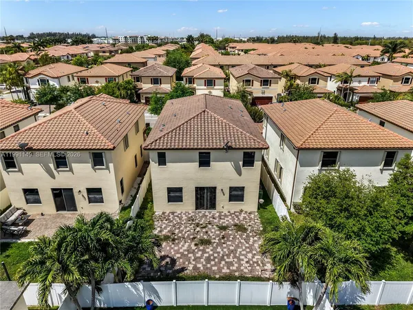 an aerial view of multiple houses with a yard