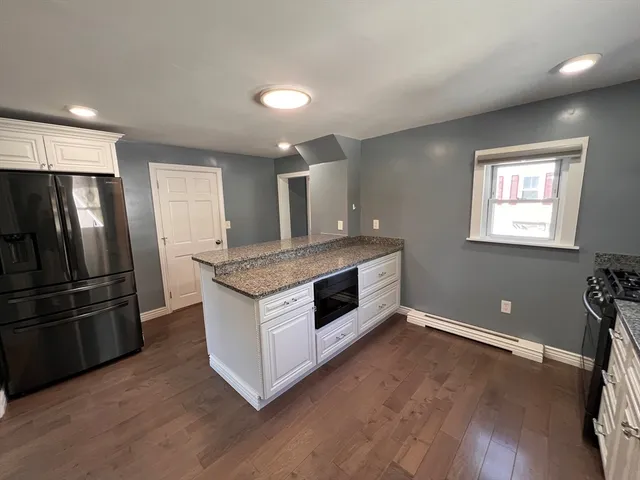 a kitchen with stainless steel appliances granite countertop a refrigerator a stove a sink and a microwave
