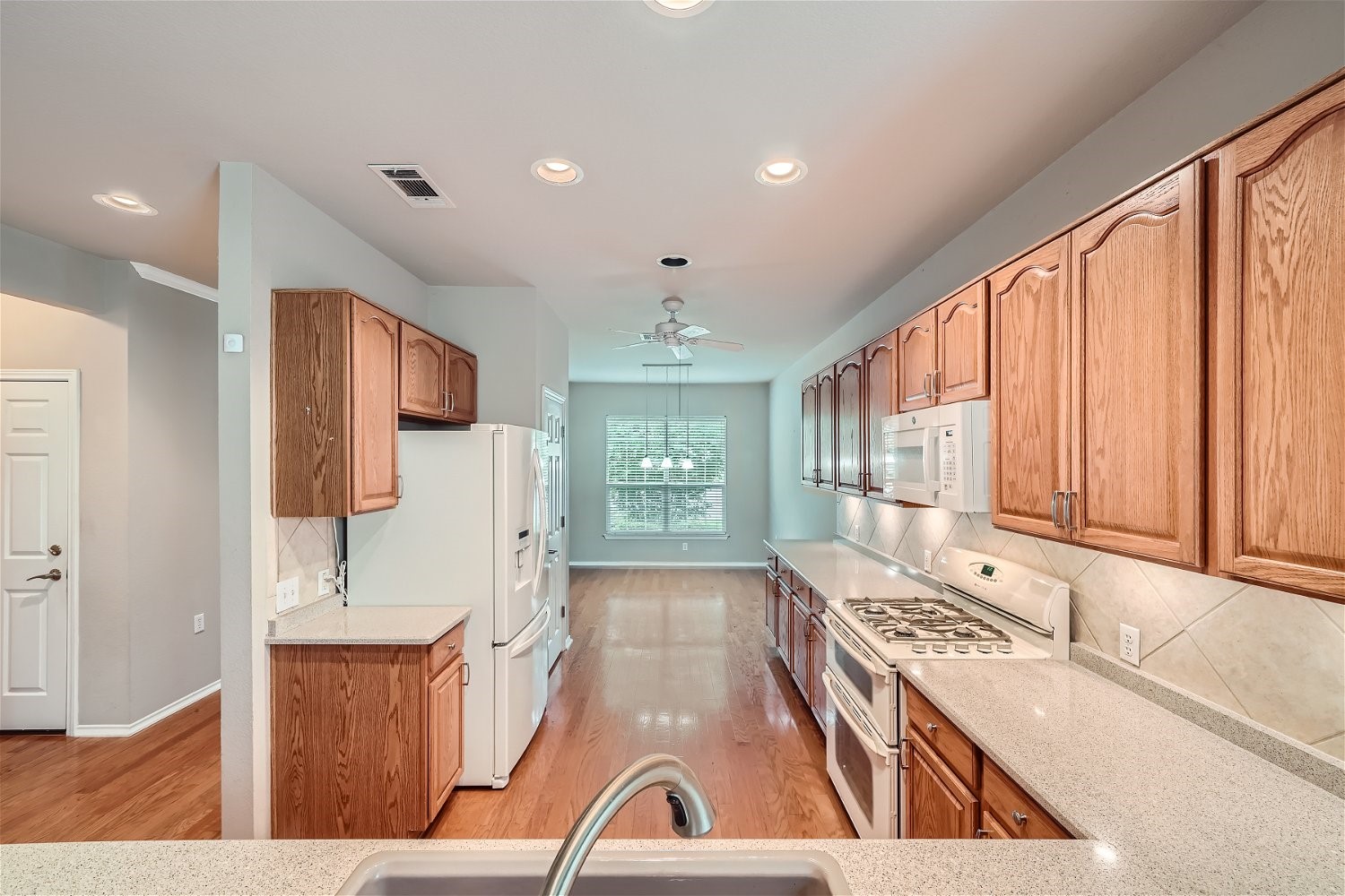 120 Muir Court Georgetown, TX 78633 - Photo 14 of 27 a kitchen with stainless steel appliances granite countertop a stove a sink dishwasher and a refrigerator with wooden floor