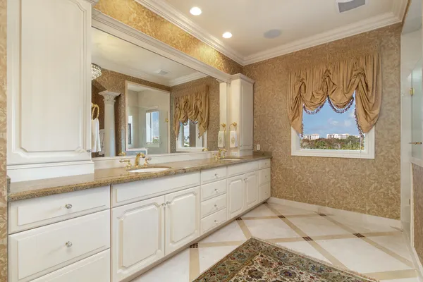 a bedroom with a bed next to a window and a chandelier