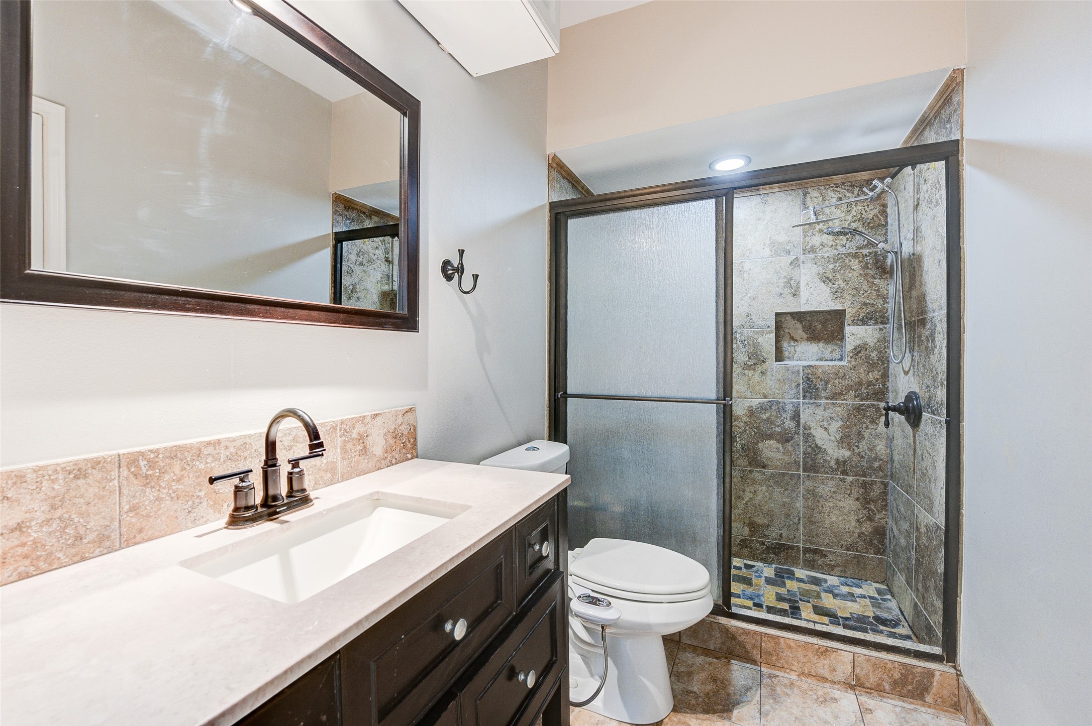 2100 Tanglewilde Street, Unit 51 Houston, TX 77063 - Photo 18 of 24 a bathroom with a sink mirror toilet and shower