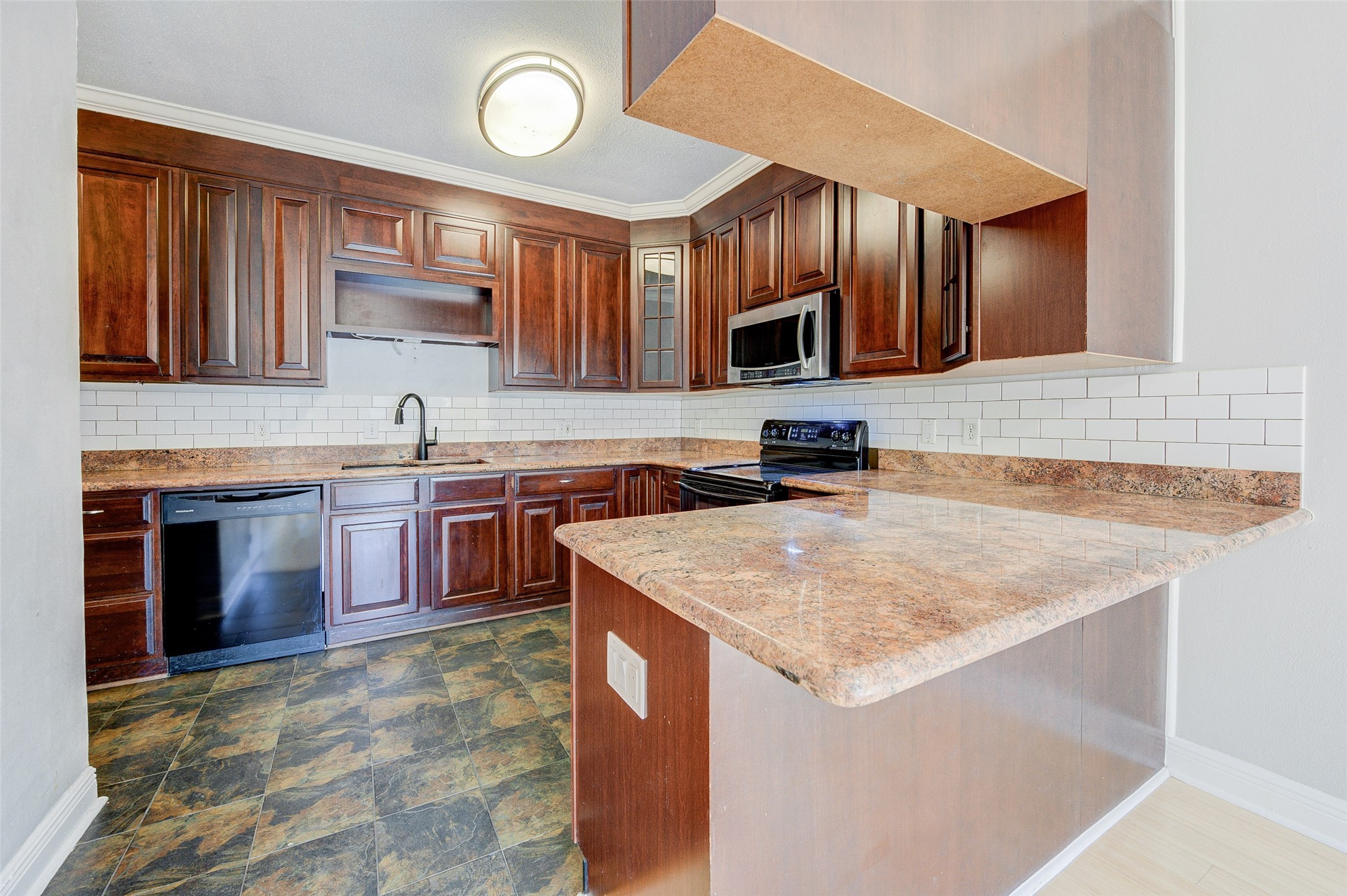 2100 Tanglewilde Street, Unit 51 Houston, TX 77063 - Photo 9 of 24 a kitchen with stainless steel appliances granite countertop a sink stove and microwave