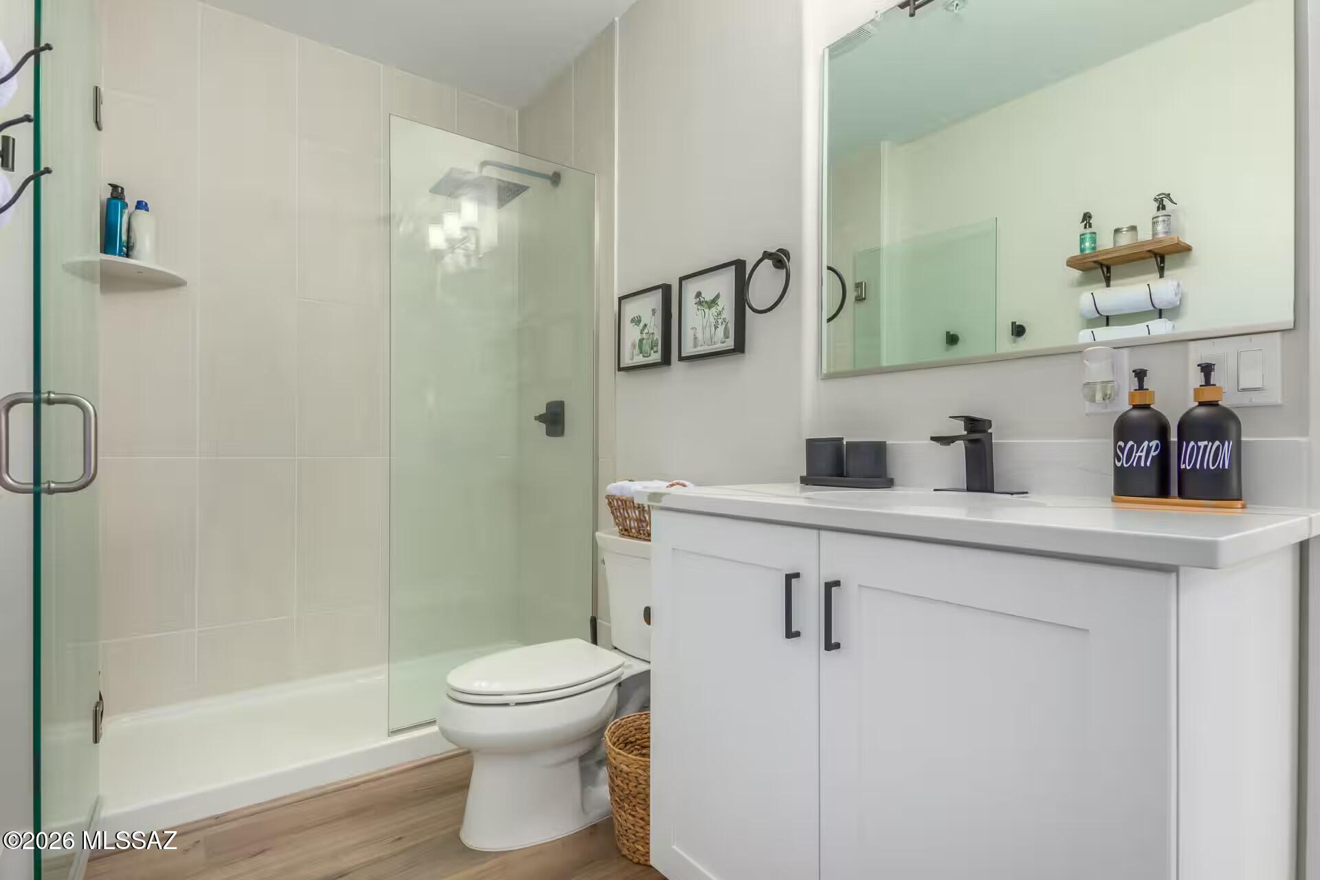 2036 East River Road, Unit 104 Tucson, AZ 85718 - Photo 15 of 23 a bathroom with a granite countertop sink a toilet and shower
