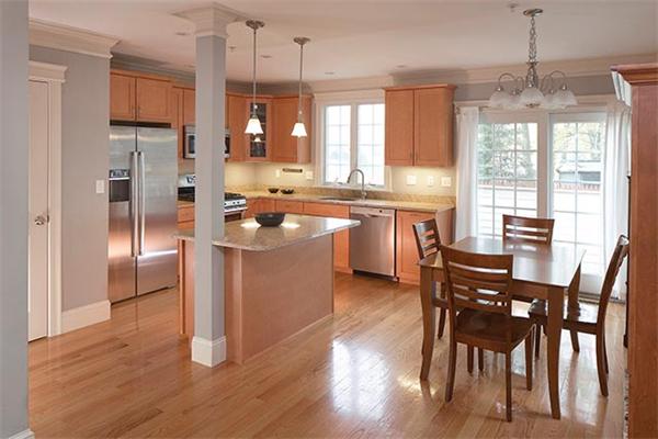 a kitchen with stainless steel appliances granite countertop a stove a refrigerator a kitchen island a dining table and chairs