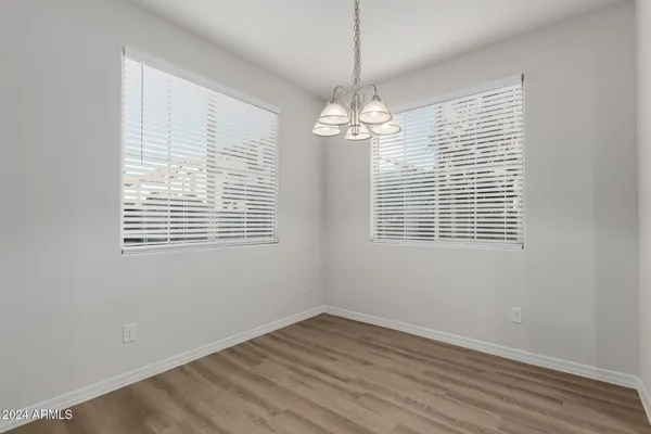 a view of empty room with wooden floor and window