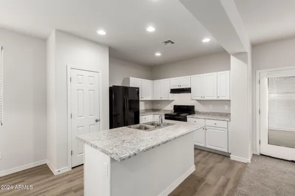 a kitchen with a refrigerator and a stove top oven