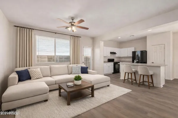a living room with furniture and view of kitchen