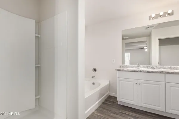 a bathroom with a granite countertop sink and a bathtub