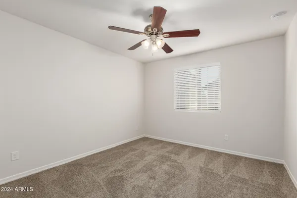 an empty room with a window and a fan