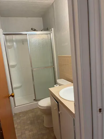 a bathroom with a granite countertop sink toilet and shower