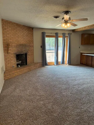 a view of an empty room with a fireplace and a window