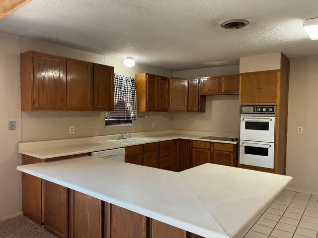 a kitchen with kitchen island a sink stainless steel appliances and cabinets