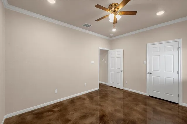 an empty room with closet and a chandelier fan