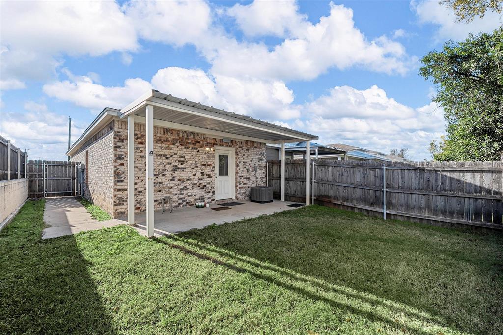 402 Spring Street McGregor, TX 76657 - Photo 14 of 15 a view of a backyard with plants and brick wall