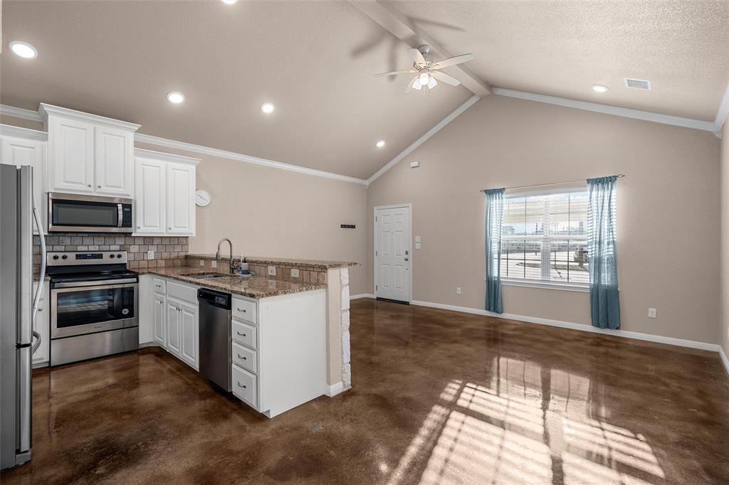 402 Spring Street McGregor, TX 76657 - Photo 3 of 15 a kitchen with a stove and a microwave