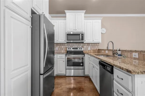 a kitchen with stainless steel appliances granite countertop a refrigerator stove and sink