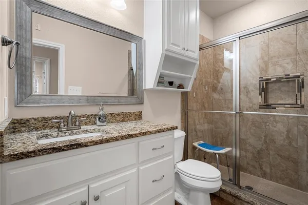 a bathroom with a granite countertop sink toilet and shower