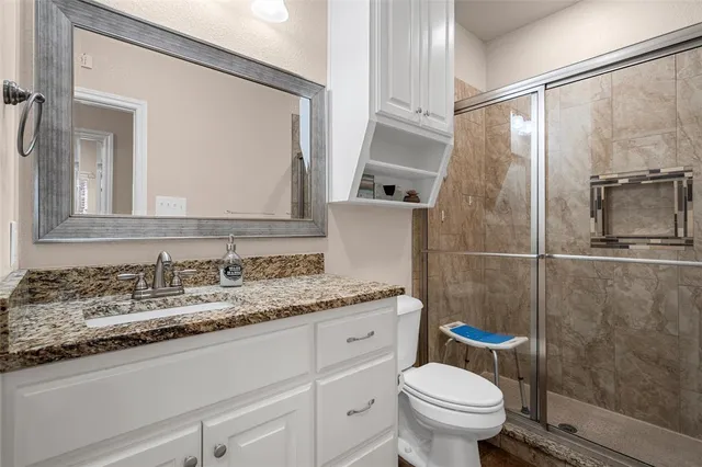 a bathroom with a granite countertop sink toilet and shower