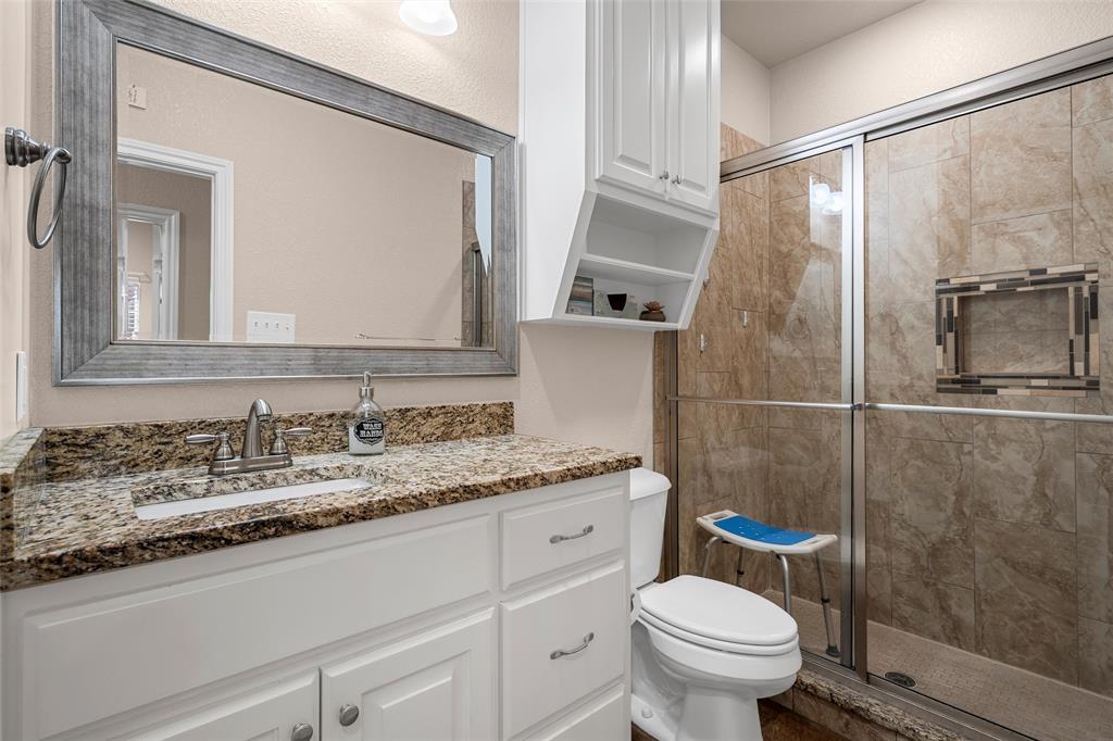 402 Spring Street McGregor, TX 76657 - Photo 7 of 15 a bathroom with a granite countertop sink toilet and shower