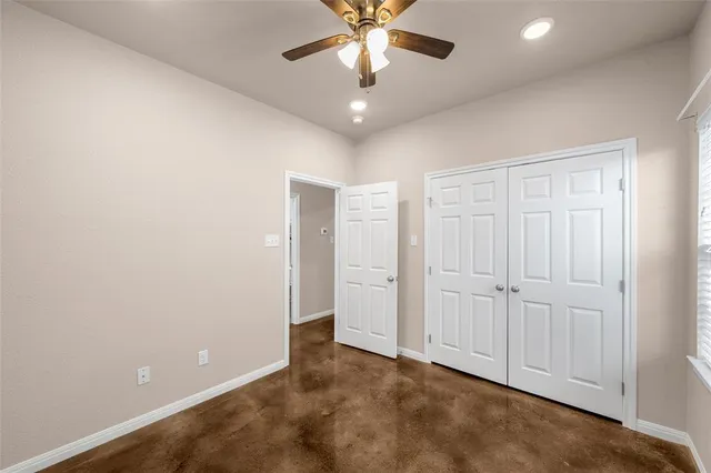 an empty room with closet and a chandelier fan