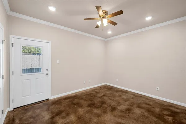 an empty room with a chandelier fan and windows