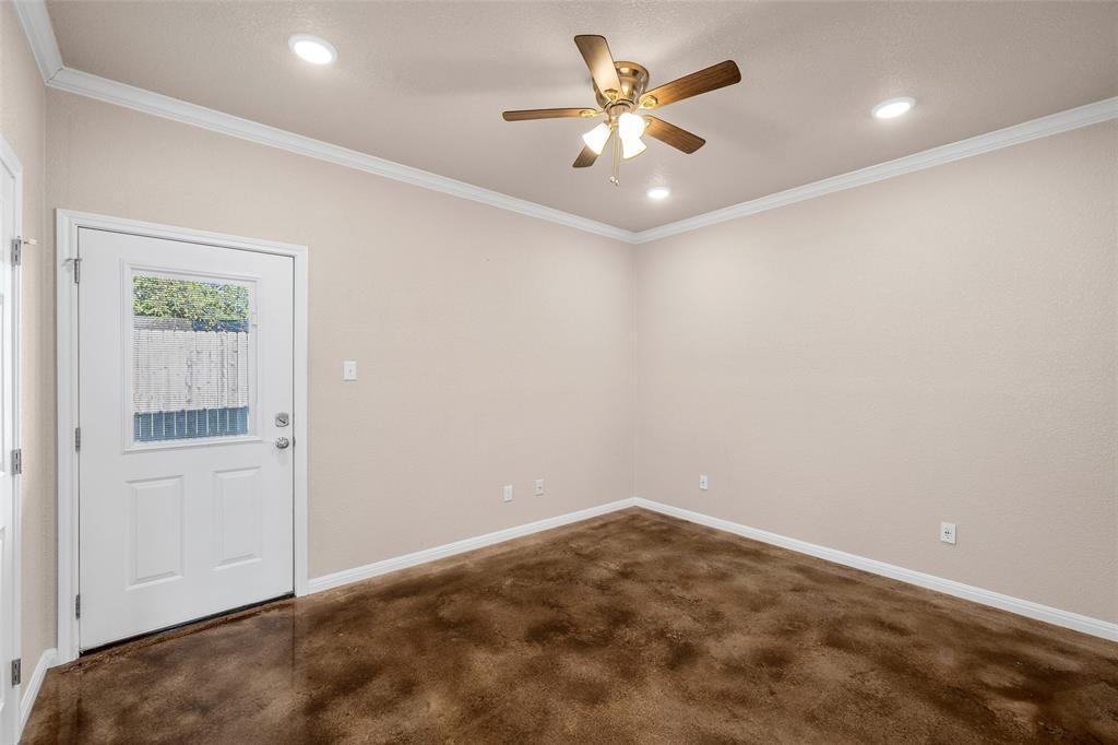 402 Spring Street McGregor, TX 76657 - Photo 10 of 15 an empty room with a chandelier fan and windows