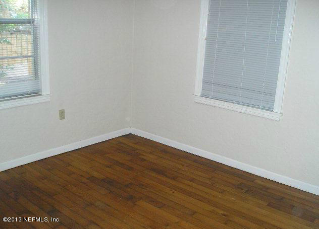 5039 Sunderland Road Jacksonville, FL 32210 - Photo 14 of 20 an empty room with wooden floor and windows
