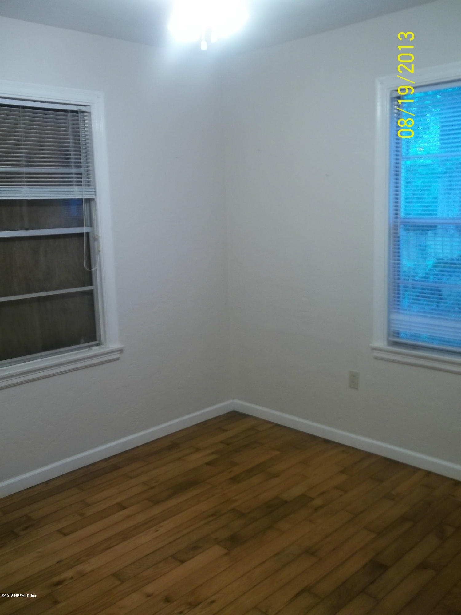 5039 Sunderland Road Jacksonville, FL 32210 - Photo 5 of 20 a view of an empty room with wooden floor and a window