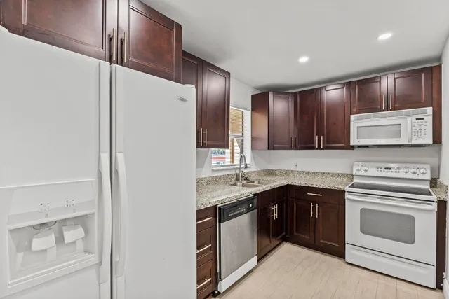 a kitchen with a stove sink and cabinets