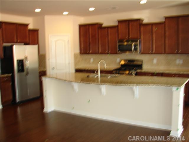 4113 Perth Road, Unit 375 Indian Land, SC 29707 - Photo 3 of 9 a kitchen with stainless steel appliances granite countertop a stove a refrigerator a sink a oven with wooden floor and cabinets