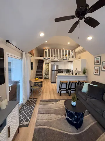 a living room with furniture and a wooden floor