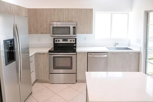 a kitchen with a sink stove and refrigerator