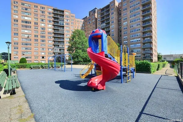 a park with multi story residential buildings and buildings in the background