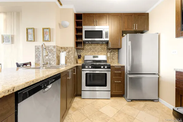 a kitchen with granite countertop a refrigerator stove and microwave